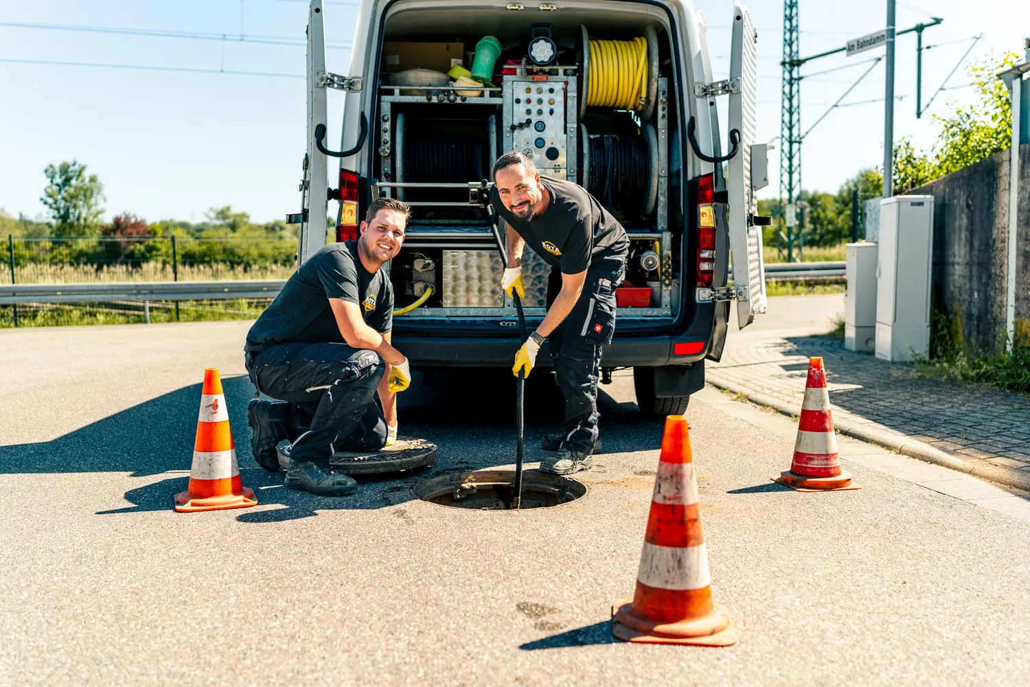 Zwei Techniker der Bota-Rohrservice e.K. arbeiten gemeinsam an einem offenen Kanalschacht